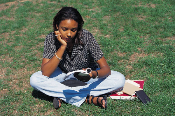 Woman reading while seated on a lawn